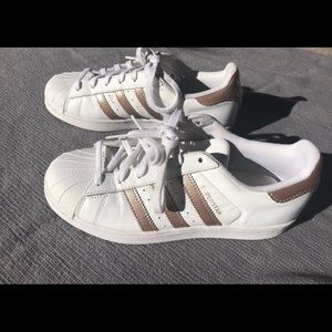 Women’s Adidas  with gold stripe, size 7.